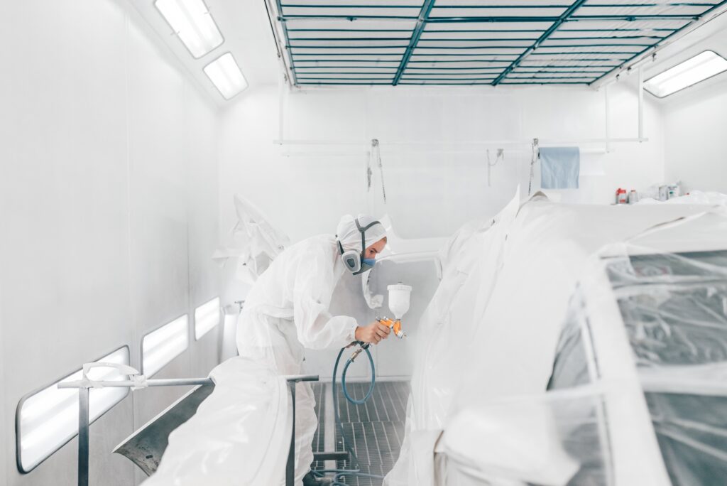Profesional car painting in a paint chamber.